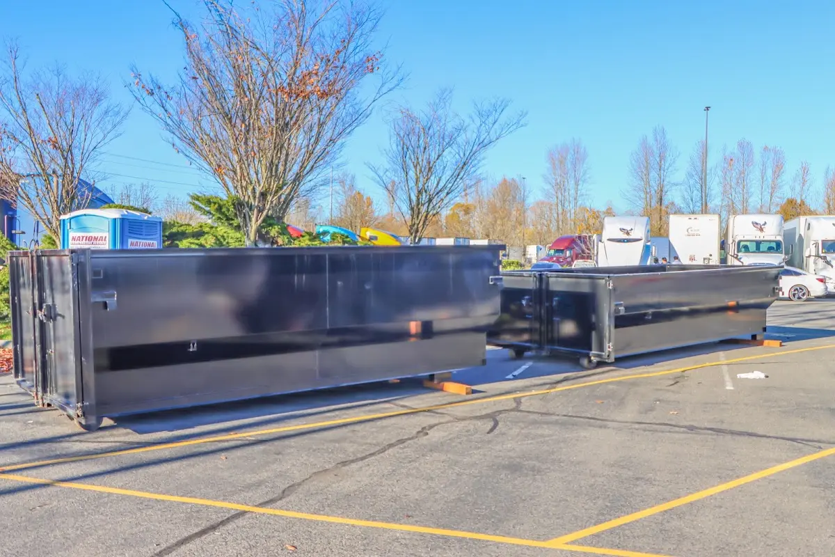 Professional dumpster rental service with roll-off container on residential driveway in Greeley